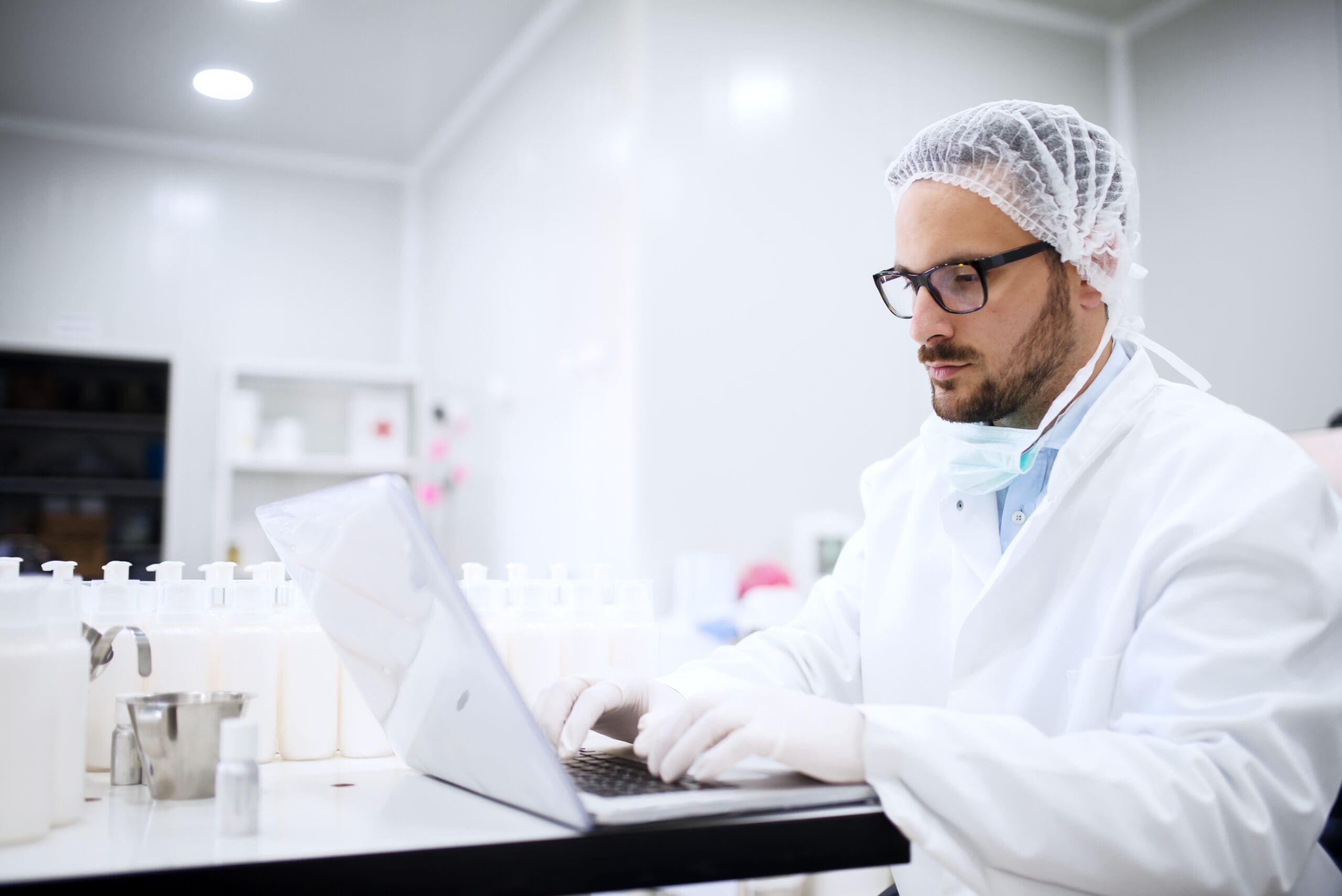 Scientist using laptop for entering test results while sitting in the lab